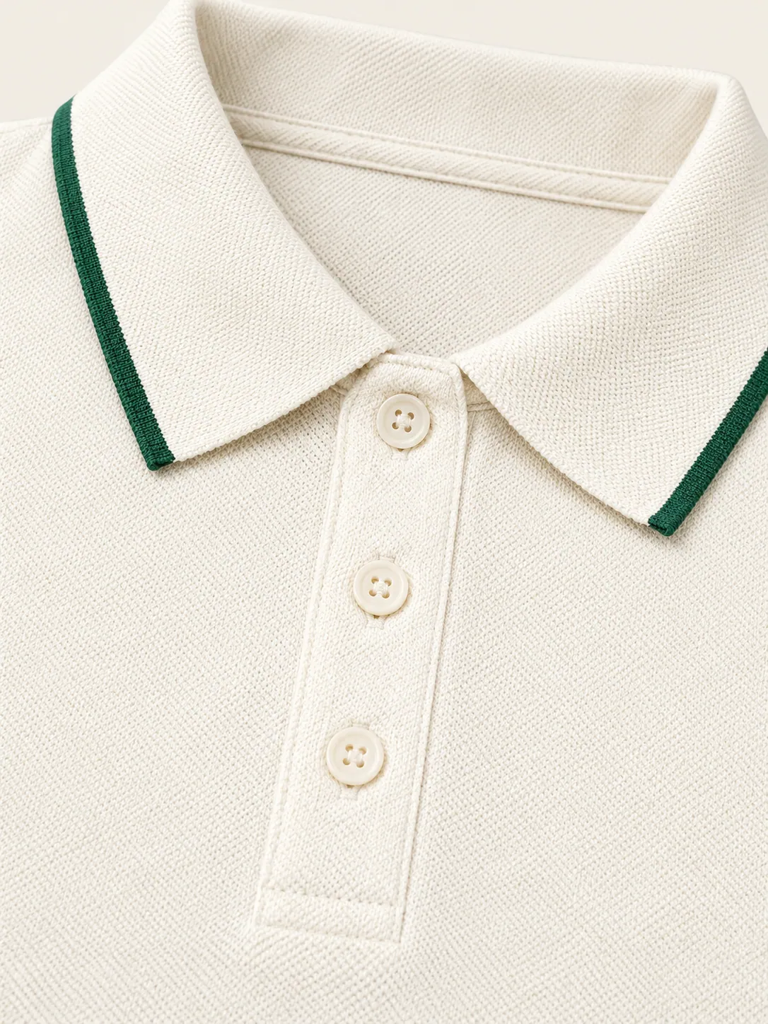 Baseline Cropped Polo, close-up of the green-tipped collar and three-button placket