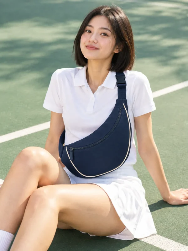 Curved Belt Sling in Ink Navy, worn at a park tennis court
