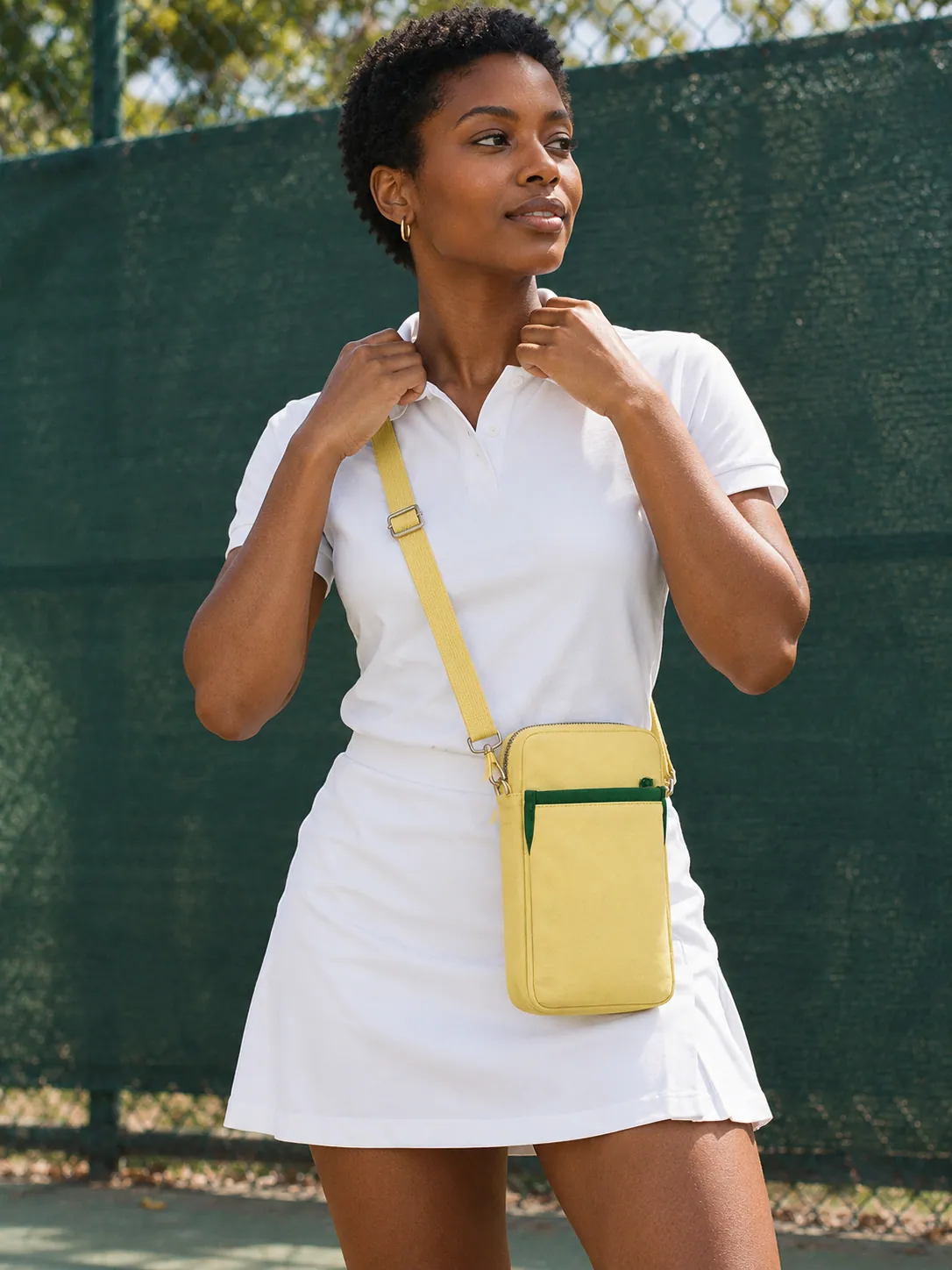 Phone Crossbody Pocket in Butter, worn at a park tennis court