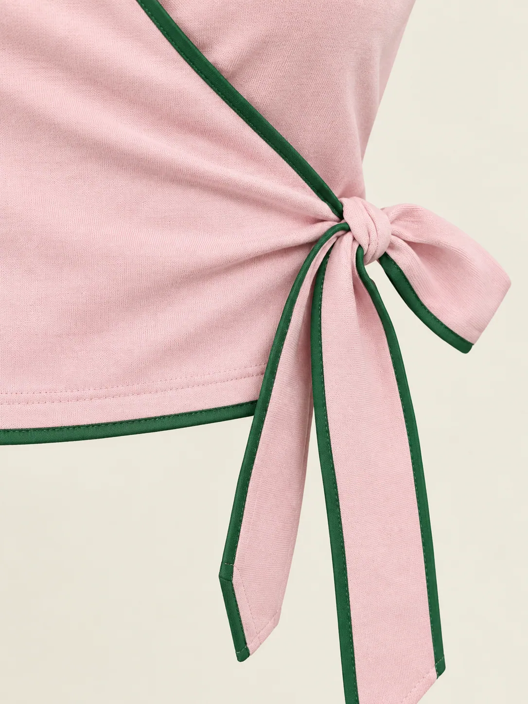 Rally Wrap Polo, close-up of the side tie and green-piped wrap edge