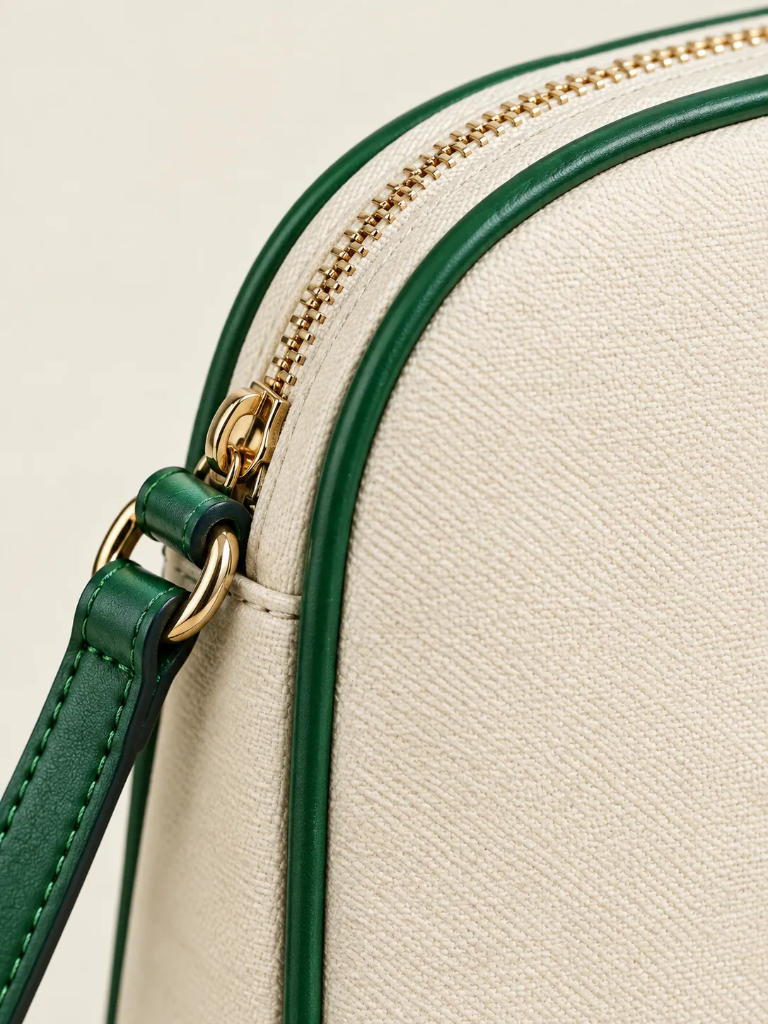Rounded-Top Crossbody, close-up of the curved zip and green piping outline