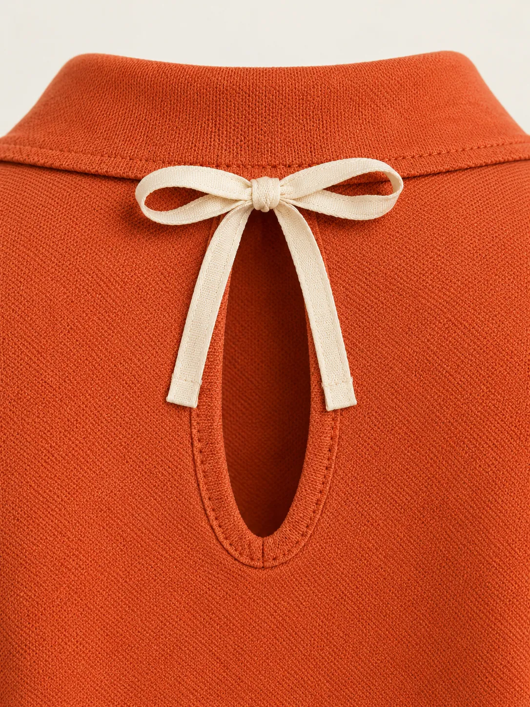 Sideline Open-Back Polo, close-up of the back keyhole and chalk bow tie