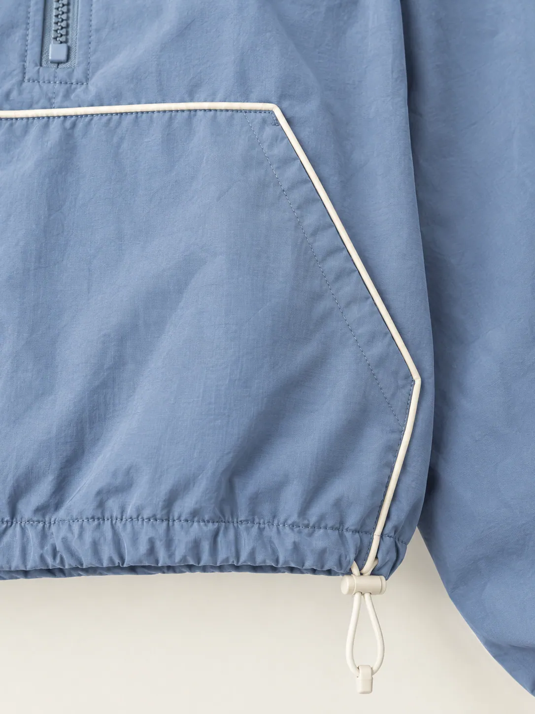 Windbreak Cropped Anorak, close-up of the chalk-piped kangaroo pocket and drawcord toggle