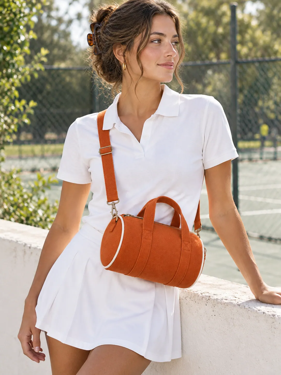 Zip Barrel Mini Bag in Clay, worn at a park tennis court